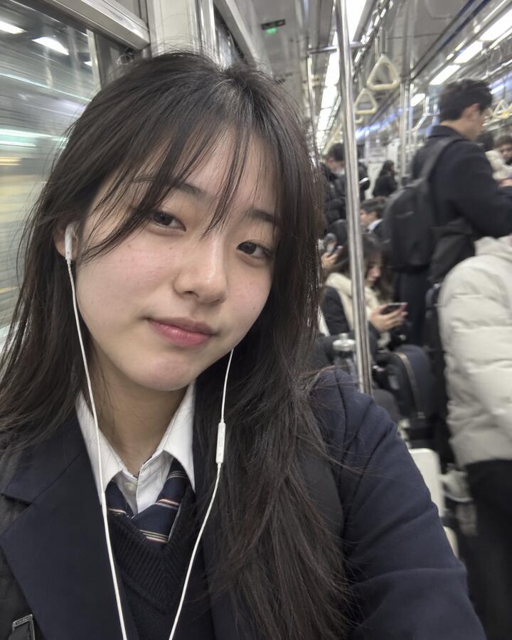 A teenager taking a selfie on the Seoul subway